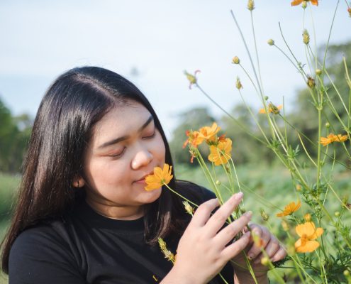 mindfulness, therapy, young woman smelling wild flowers