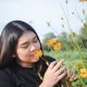 mindfulness, therapy, young woman smelling wild flowers