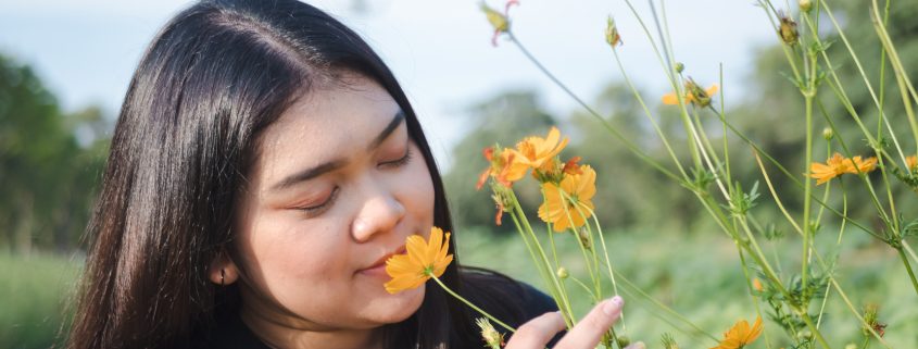 mindfulness, therapy, young woman smelling wild flowers