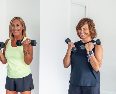 two-mature-sporty-women-smiling-while-doing-bicep-curls-with-weights-ways-to-stick-to-fitness-routine-for-mental-health
